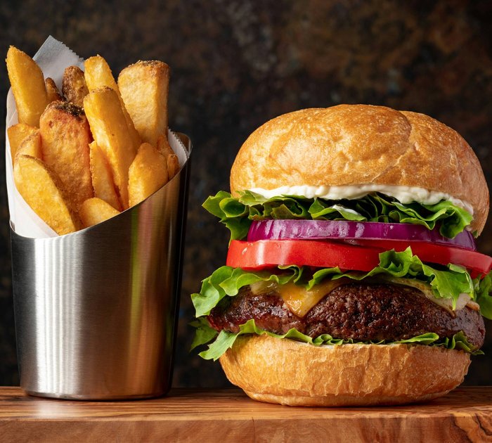 Pure Flexibilität im TYROL Family Retreat Cheeseburger mit Salat, Tomate, Zwiebel und Pommes in Metallbecher