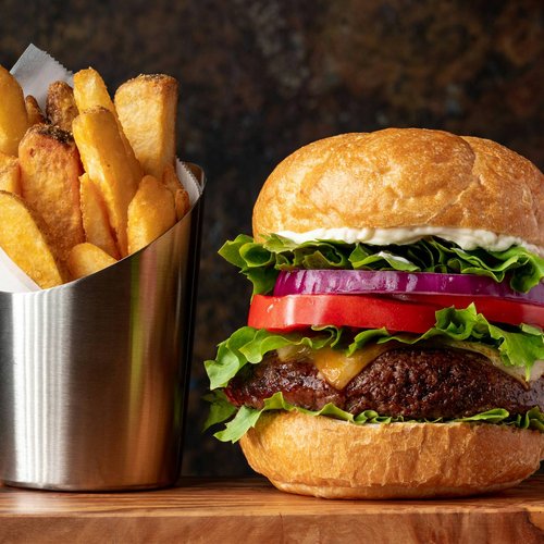 Pure Flexibilität im TYROL Family Retreat Cheeseburger mit Salat, Tomate, Zwiebel und Pommes in Metallbecher