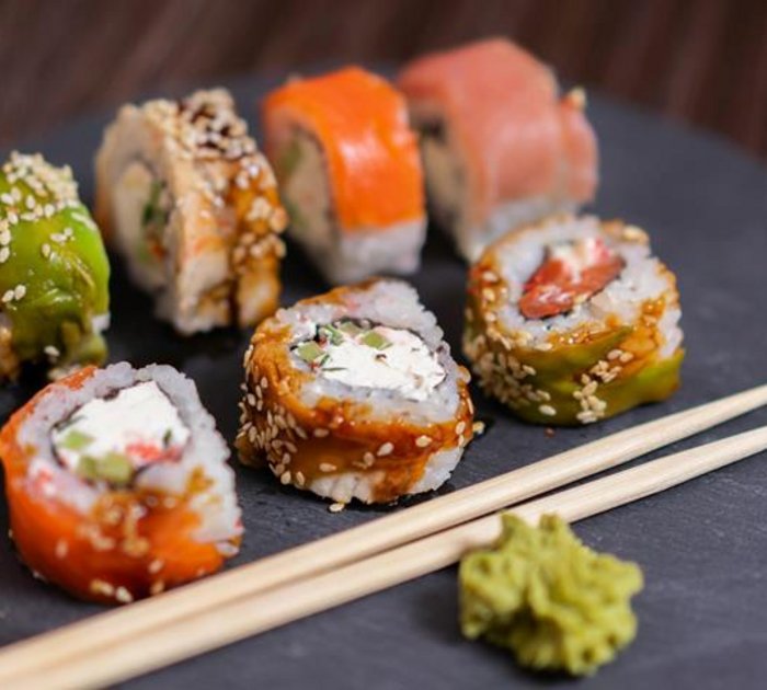 Pure Flexibilität im TYROL Family Retreat Verschiedene Sushi-Rollen mit Wasabi und Essstäbchen auf schwarzem Teller