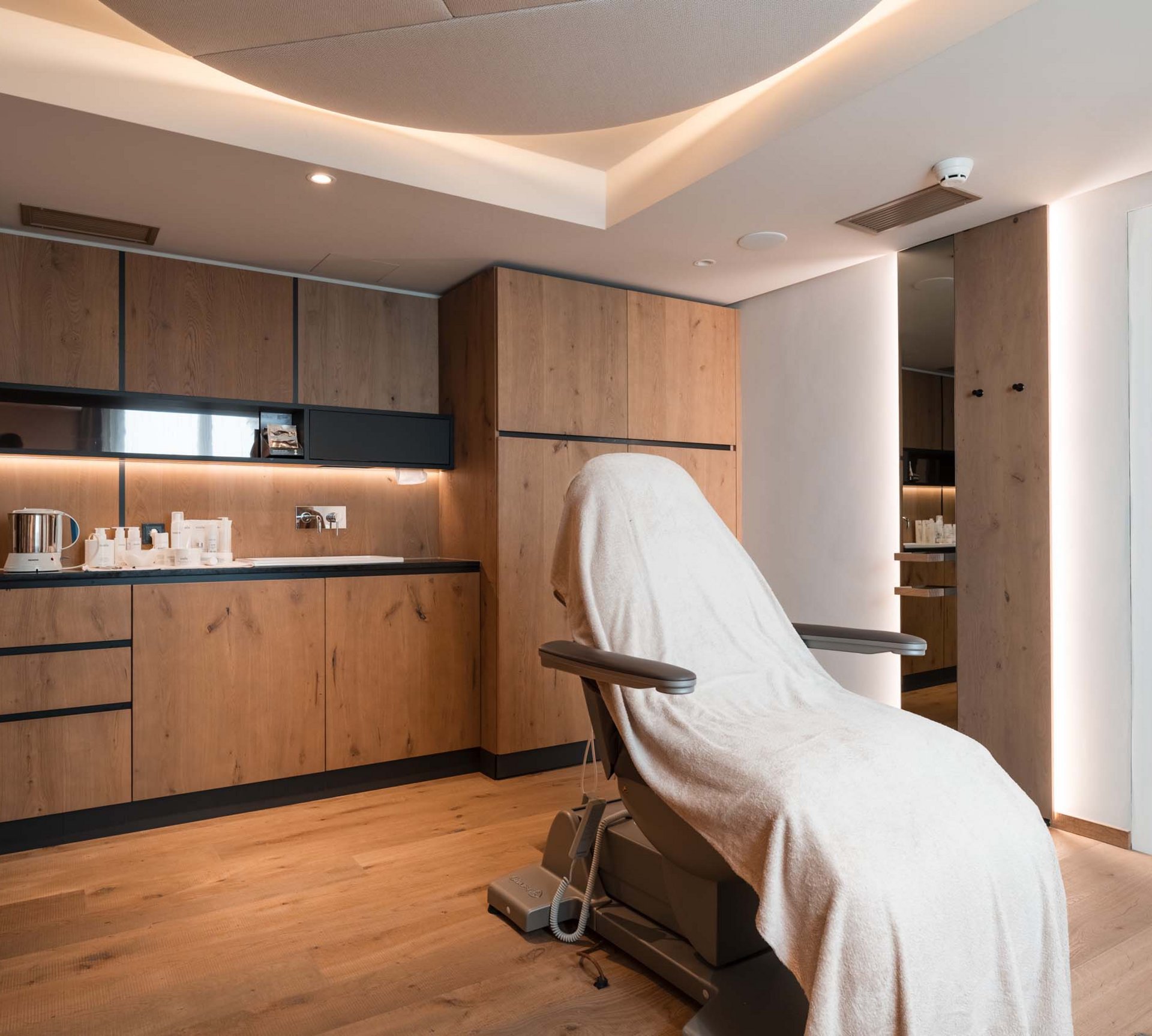 Erholung im Wellnesshotel in Naturns Behandlungsraum mit moderner Liege und Holzmöbeln