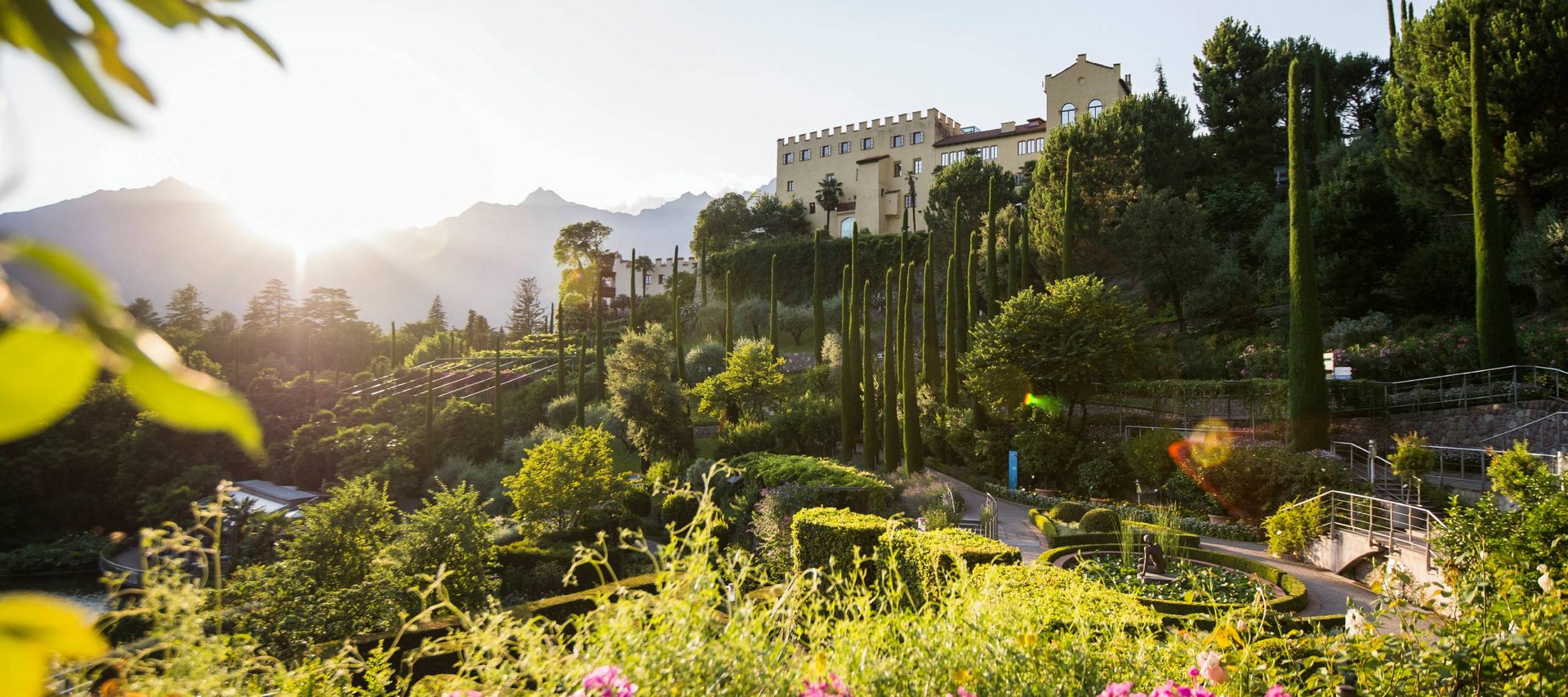 Euer vielseitiger Urlaub in Naturns Schloss mit Garten, hohen Zypressen und Sonnenuntergang in den Bergen