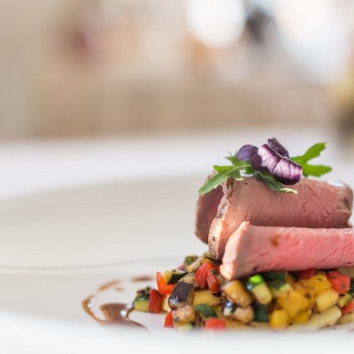 Pure Flexibilität im TYROL Family Retreat Rinderfilet mit Gemüsewürfeln auf weißem Teller angerichtet