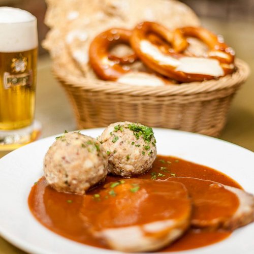 Pure Flexibilität im TYROL Family Retreat Bayerisches Essen mit Knödeln, Schweinebraten, Brezeln und Bier