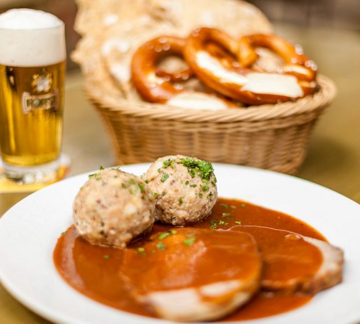 Pure Flexibilität im TYROL Family Retreat Bayerisches Essen mit Knödeln, Schweinebraten, Brezeln und Bier