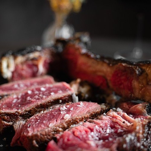 Pure Flexibilität im TYROL Family Retreat Nahaufnahme von in Scheiben geschnittenem rosa, saftigem Steak auf dunklem Teller
