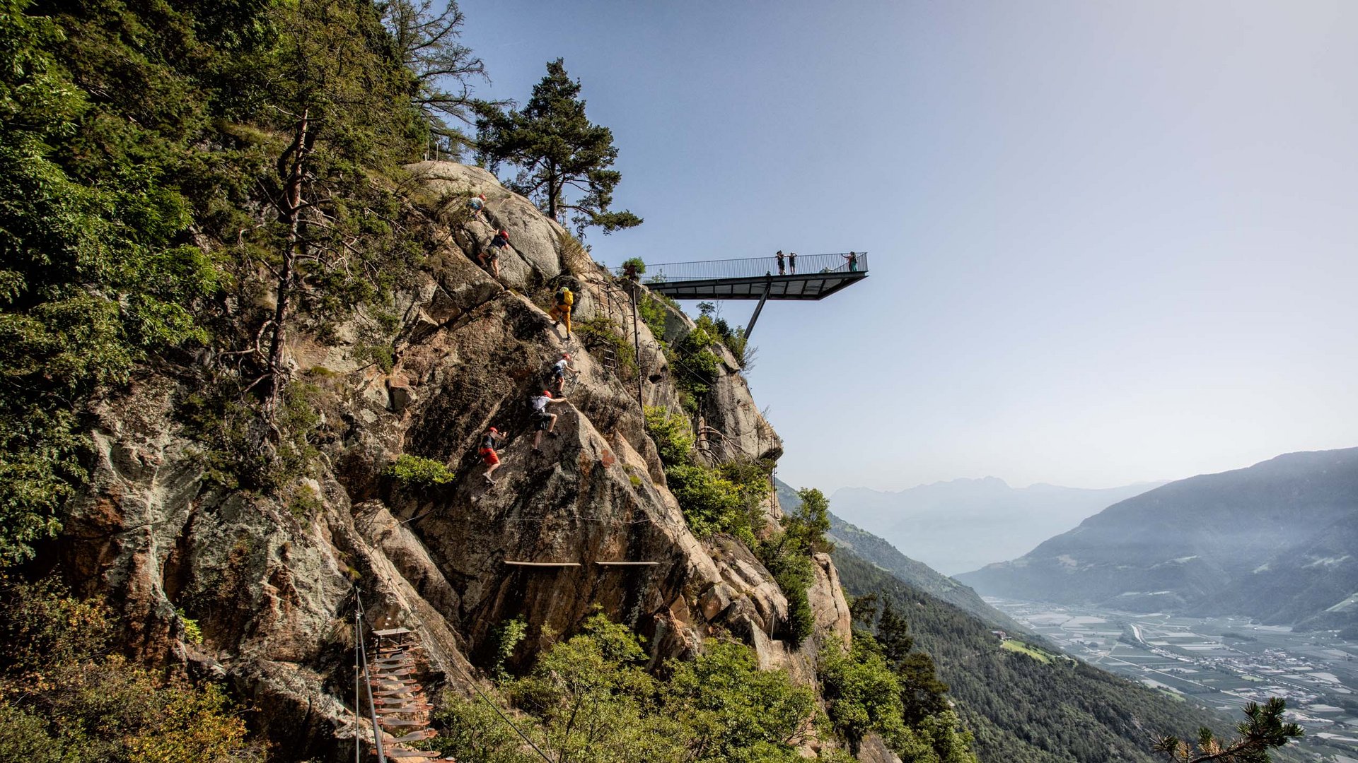 Euer vielseitiger Urlaub in Naturns Kletterer steigen an Felsen mit Aussichtspunkt und Talblick