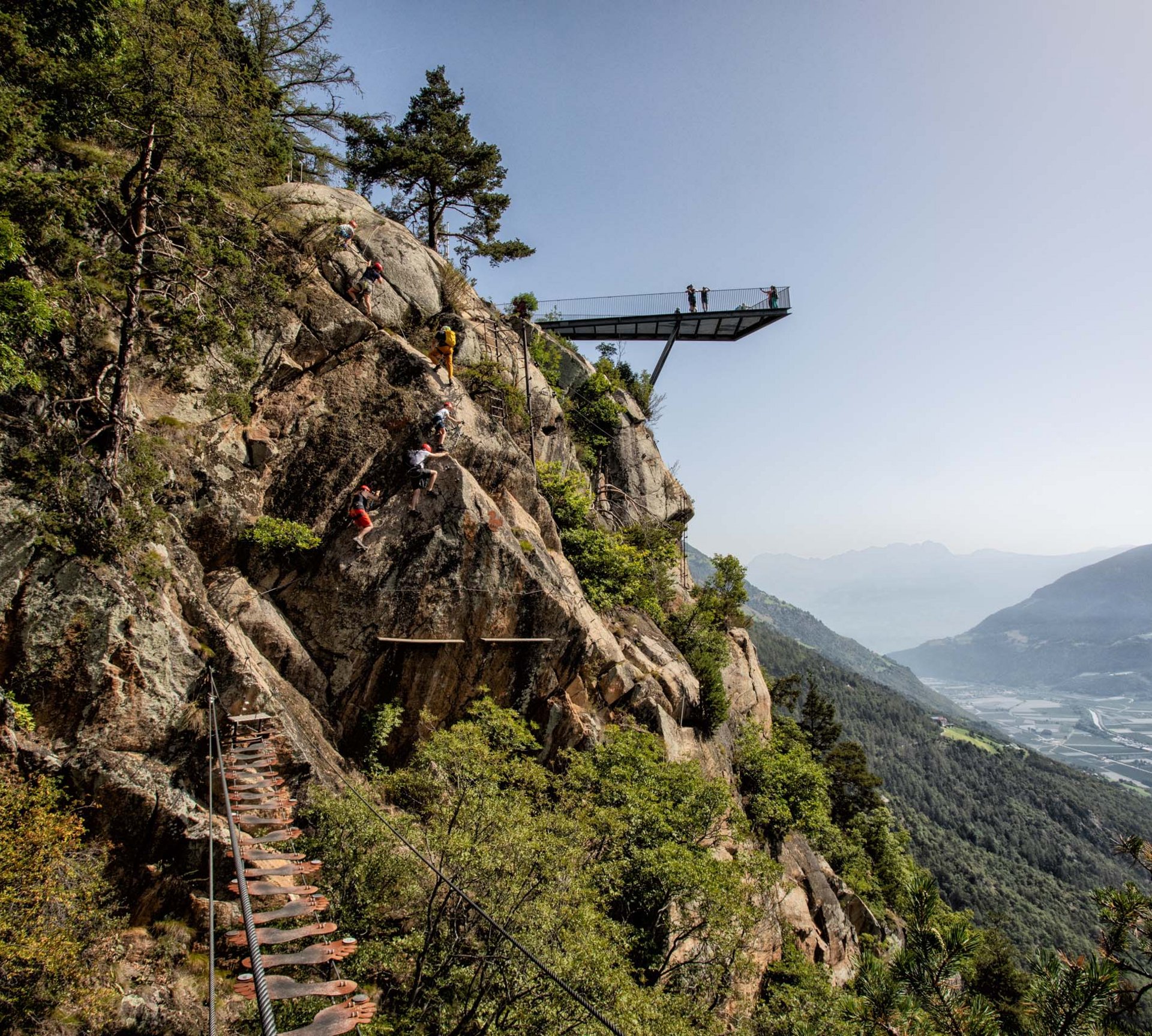 Gesunde Bewegung im Sporthotel in Naturns Kletterer steigen an Felsen mit Aussichtspunkt und Talblick