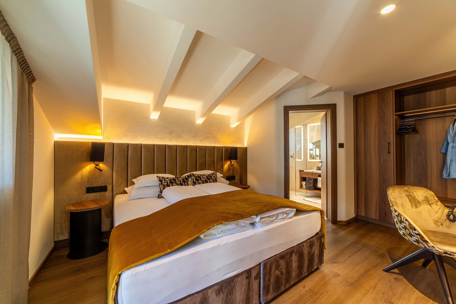 Königlicher Urlaub im Aparthotel nahe Meran und Umgebung Gemütliches Schlafzimmer mit Doppelbett, indirekter Beleuchtung und offenem Bad