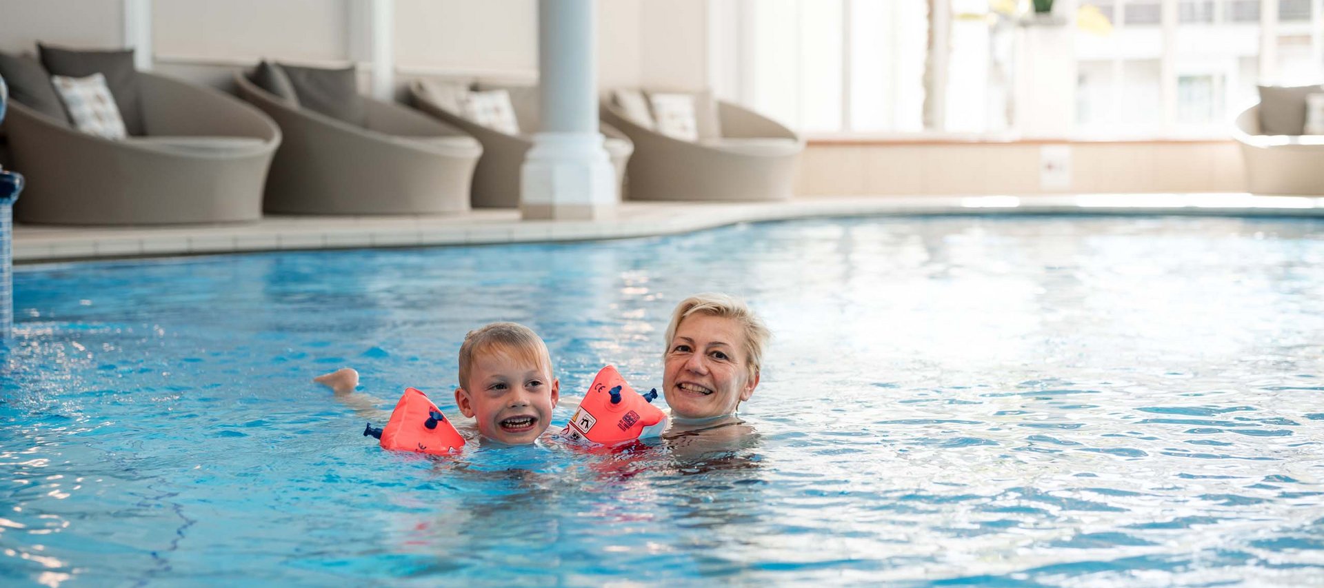 Euer Familienhotel mit Schwimmkurs in Südtirol Frau und Kind schwimmen zusammen im Hallenbad