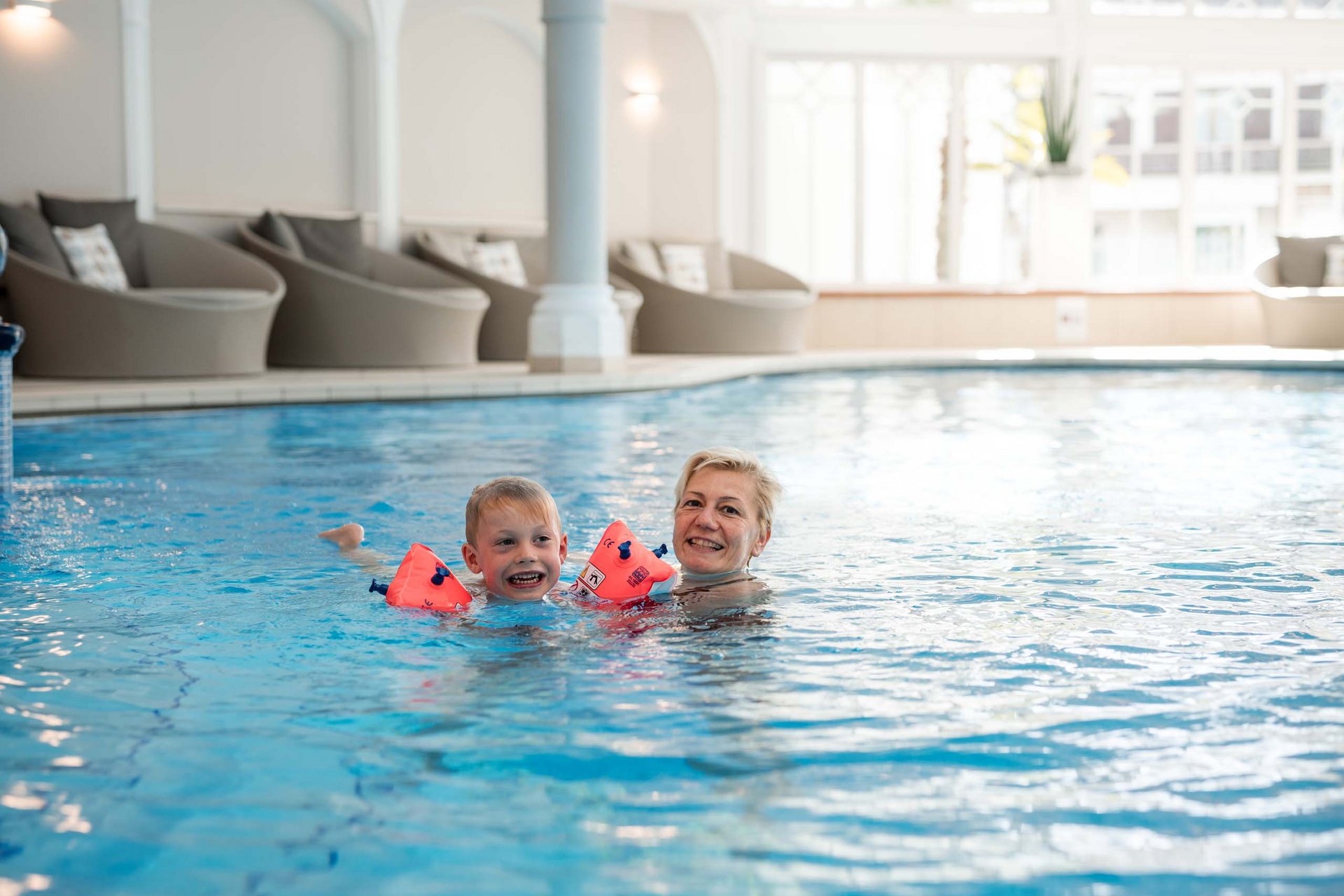 Königlicher Wasserspaß im Familienhotel in Naturns mit Pool Frau und Kind schwimmen zusammen im Hallenbad
