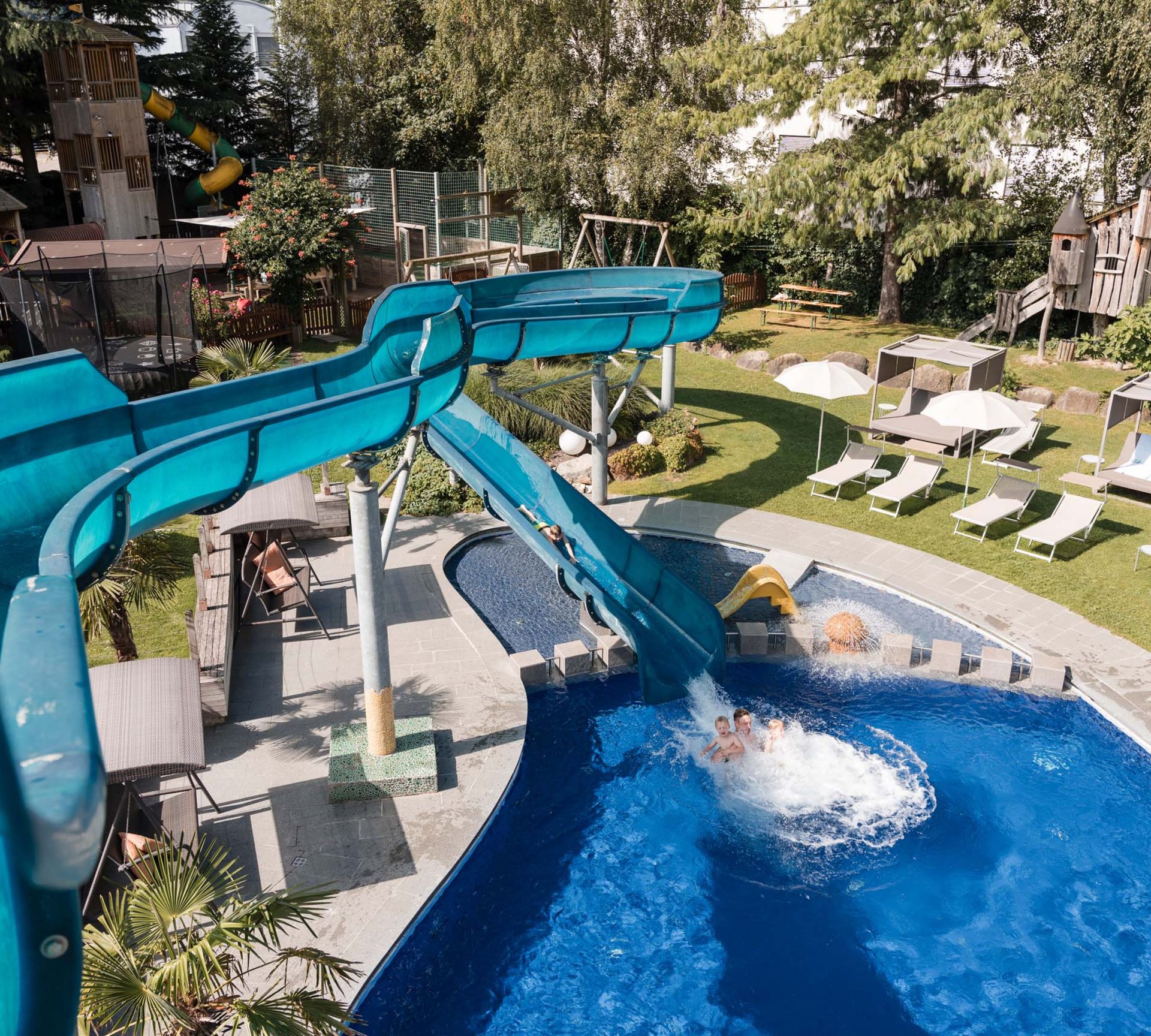 Ab ins Familienhotel in Südtirol mit Wasserrutsche! Wasserpark mit Rutsche, Schwimmbecken und Liegestühlen im Freien