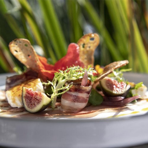 Pure Flexibilität im TYROL Family Retreat Fein angerichteter Teller mit Feigen, Speck, Salat und Crostini