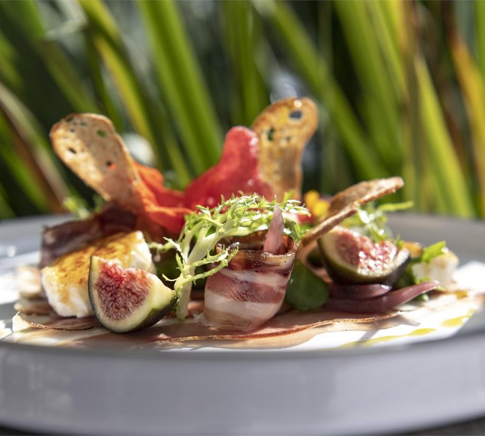 Pure Flexibilität im TYROL Family Retreat Fein angerichteter Teller mit Feigen, Speck, Salat und Crostini